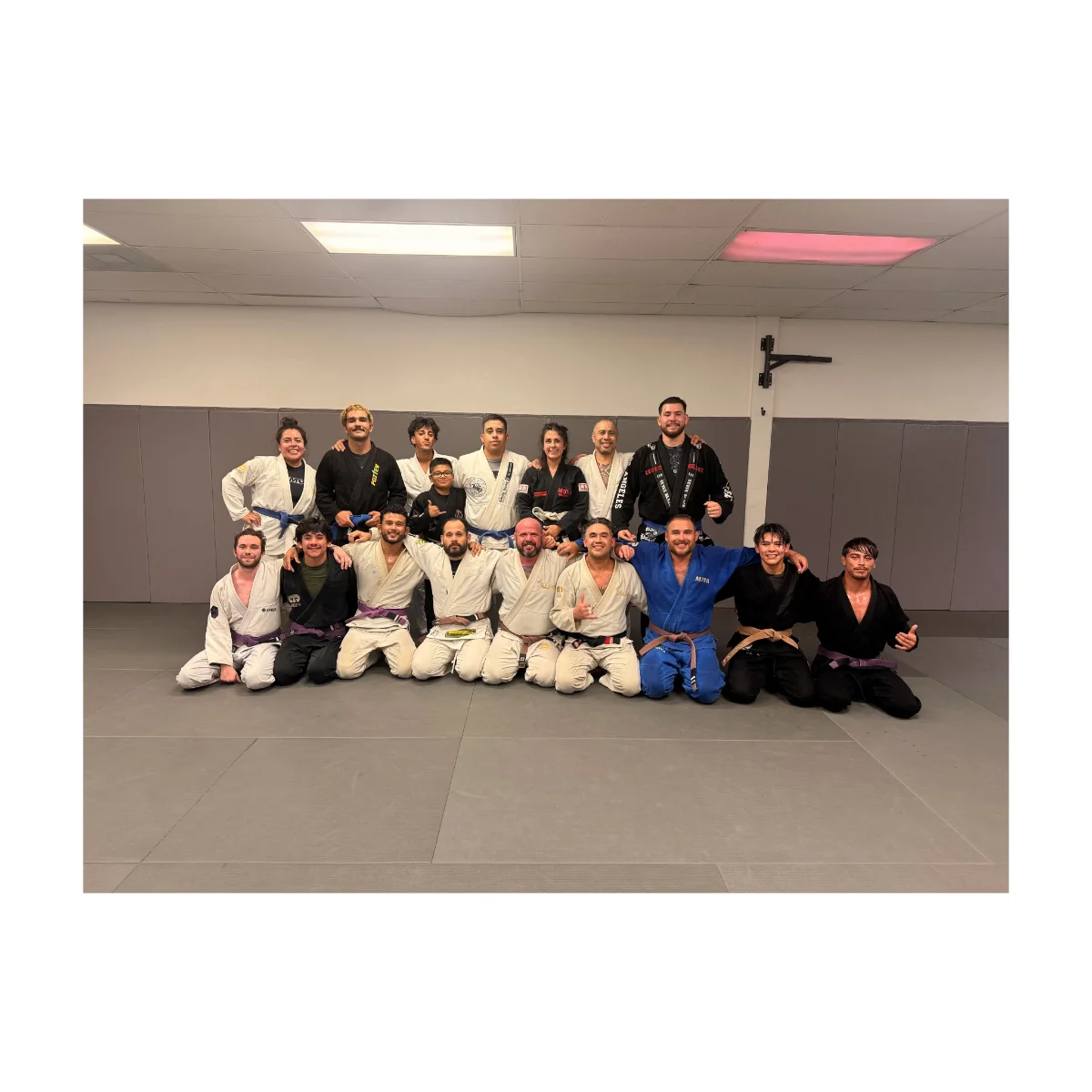 Two adult students drilling a gi jiu-jitsu technique during an all-levels class