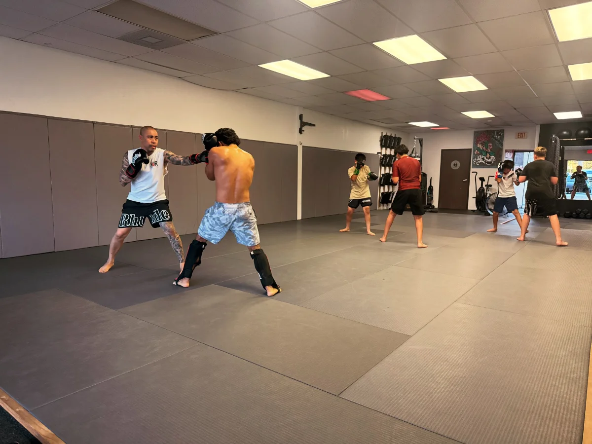Adult boxing student working the mitts with a coach